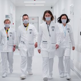 Medical team walking confidently in a hospital corridor, wearing face masks and white coats, symbolizing teamwork and healthcare dedication.